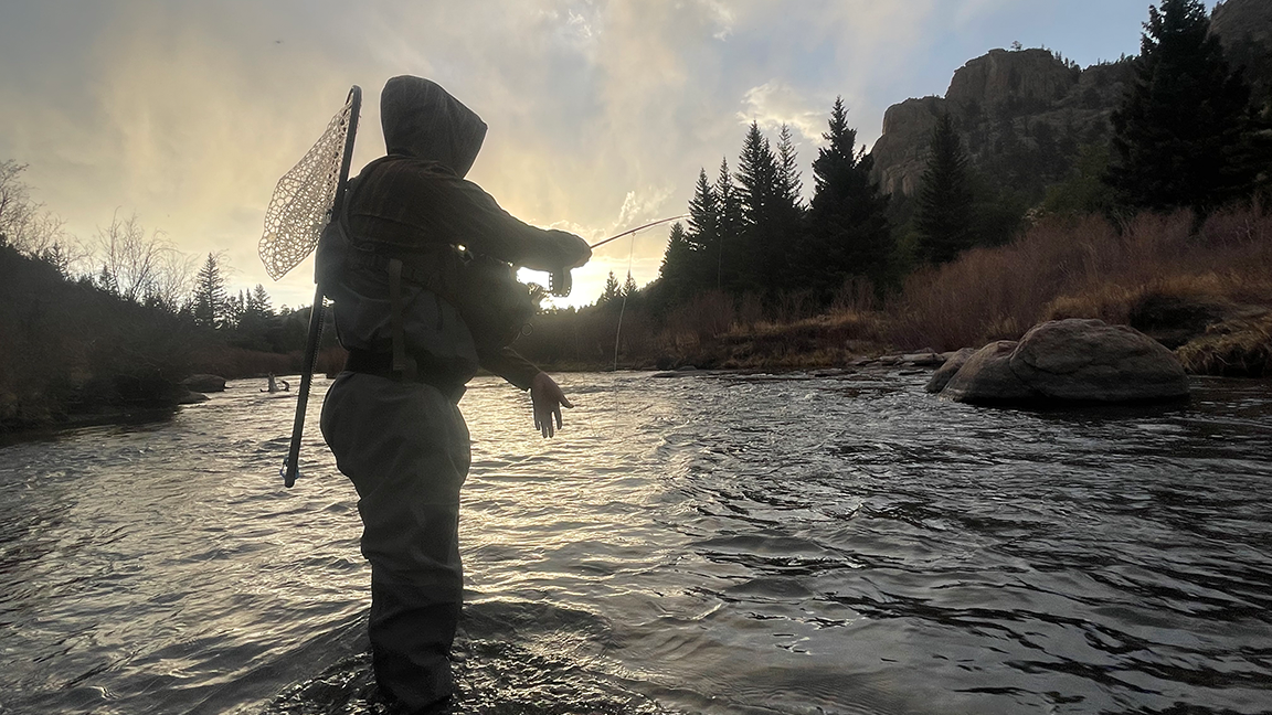 A photo of a man fly fishing the South Platte river in his Headwater Canyon Hoodie