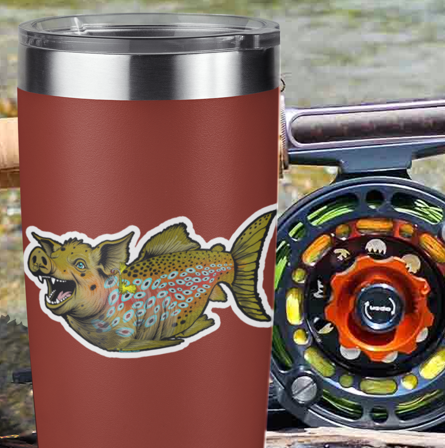 Picture of the Headwater Canyon Boss Hog fly fishing decal on a coffee mug with a fly fishing rod in the background.  pig crossed with a brown trout trophy fish. Waterproof sticker.