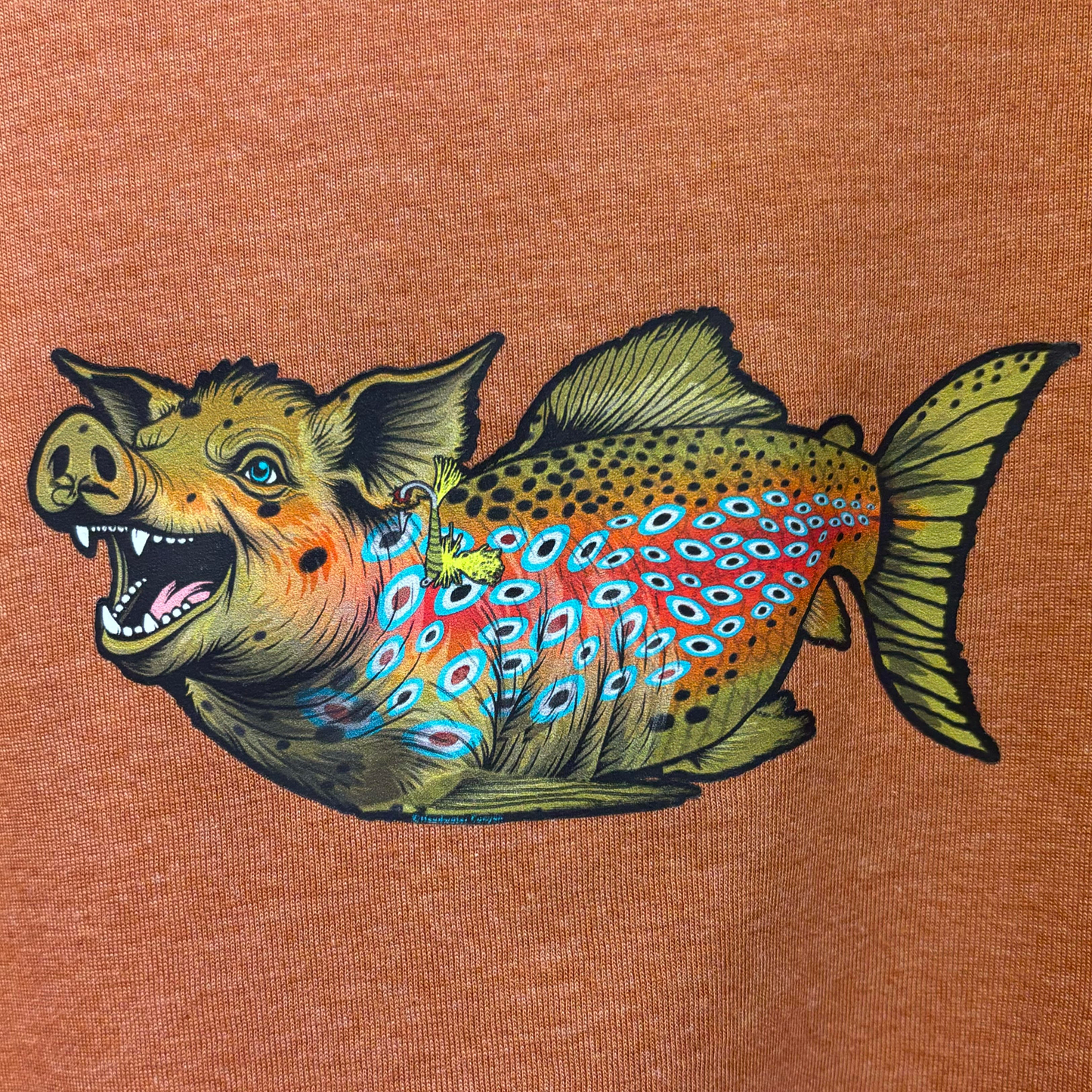 A rust colored fly fishing t shirt depicting a pig as a huge brown trout.  Headwater Canyon Boss Hog Tee.
