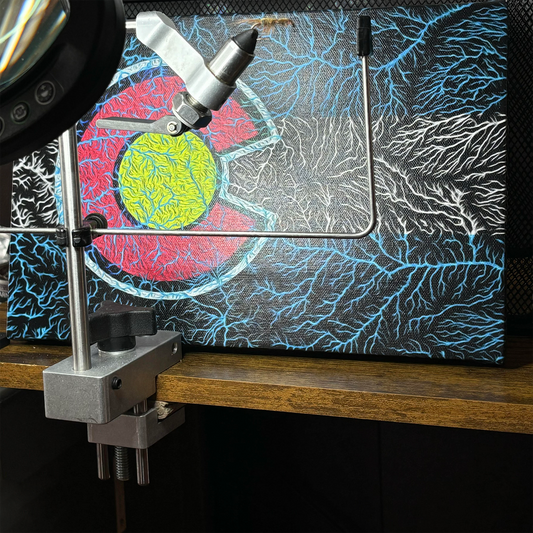 The Colorado Watersheds Canvas Wall Art by Headwater Canyon. 8" X 12" canvas behind a fly tying vice.