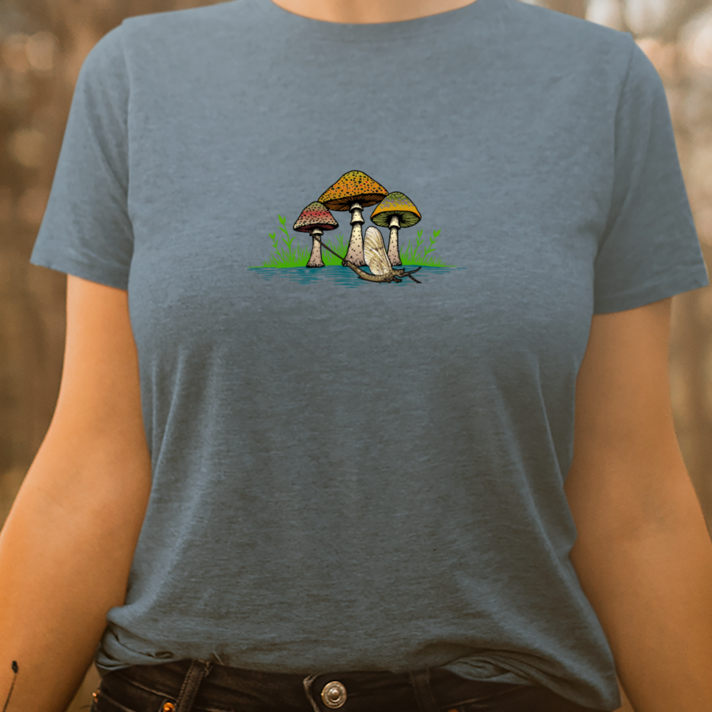 Women's fly fishing t shirt.  Deep Teal colored women's tee.  The Seems Fishy Tee by Headwater Canyon.  Fly fishing shirt depicts three mushrooms with trout patterns behind a mayfly on a woman model.