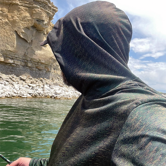 Fly fisher on the lake fishing while wearing the   Headwater Canyon Adventurer Sun Hoodie.  Performance USA made sun protection hooded shirt.