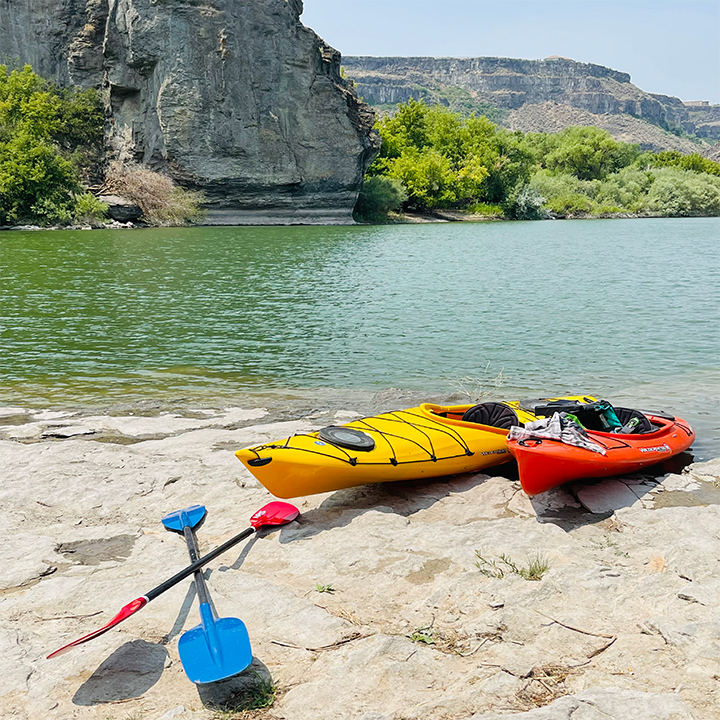 A picture of two kayaks on the shore of the Snake River in Idaho.